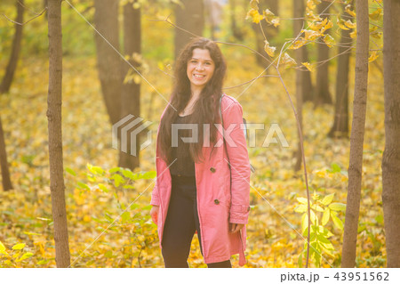 Autumn, nature and people concept - Portrait of plus size woman in pink jacket in park 43951562