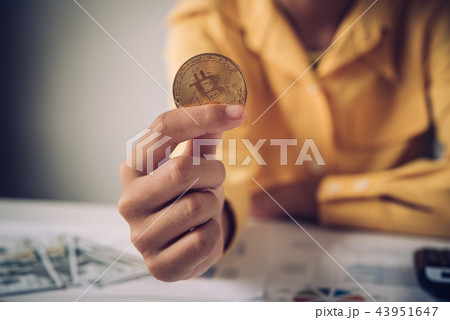 Hand of a businessman holding a gold bitcoin 43951647