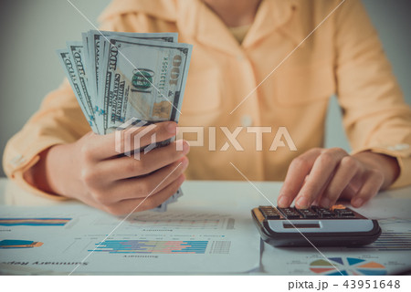 businesswoman using calculator and holding money 43951648