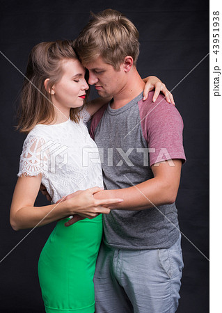 Beautiful young couple hugging and kissing isolated on black background. Beautiful young couple hugging and kissing isolated on black background. 43951938