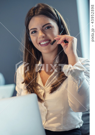 Customer Service agent in an startup office with laptop Customer Service agent in an startup office with laptop 43952898