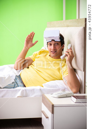 Young man with virtual glasses in the bedroom  43954772