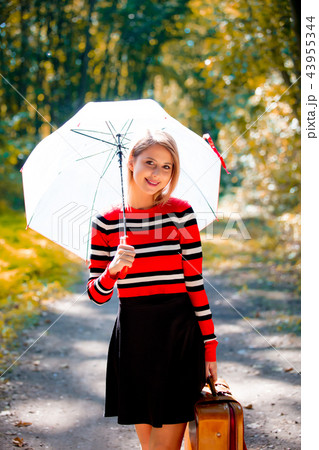 girl with umbrella and suitcase in autumn park  43955344