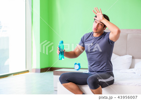 Young handsome man doing morning exercises in the hotel room 43956007