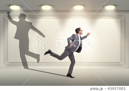 Businessman and his shadow in business concept Businessman and his shadow in business concept 43957001