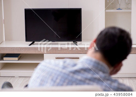 Young man watching tv at home 43958084