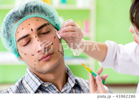 Plastic surgeon preparing for operation on man face 43962286