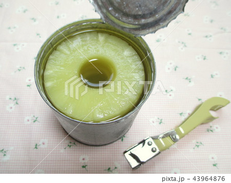 パイナップルの缶詰を缶切りで開けるの写真素材
