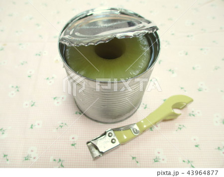 パイナップルの缶詰を缶切りで開けるの写真素材