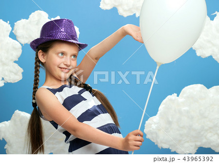 girl posing on blue background with cotton clouds 43965392