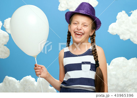 girl posing on blue background with cotton clouds 43965396