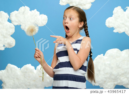 girl posing on blue background with cotton clouds 43965417