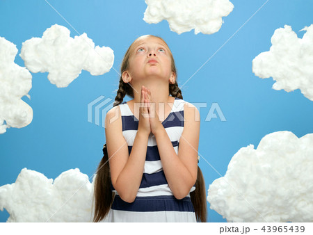 girl posing on blue background with cotton clouds 43965439