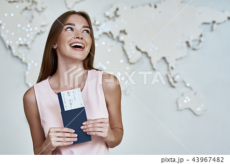 Happy young woman with passports and tickets in the office of travel company Happy young woman with passports and tickets in the office of travel company 43967482