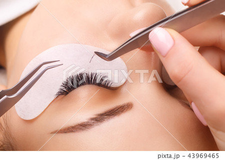 Eyelash Extension Procedure. Woman Eye with Long Eyelashes. Close up, selective focus. 43969465