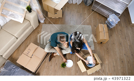 Young couple Moving in new home and unpacking carboard boxes. Young couple Moving in new home and unpacking carboard boxes. 43971322