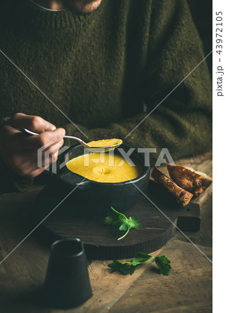 Man in dark sweater eating sweet corn and shrimp soup Man in dark sweater eating sweet corn and shrimp soup 43972105