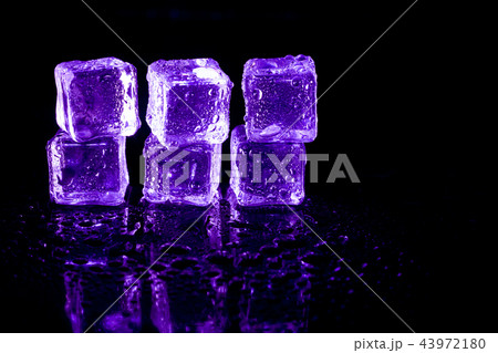 Purple ice cubes reflection on black table. 43972180