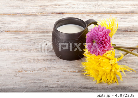 Ceramics handmade mug with milk and flowers 43972238