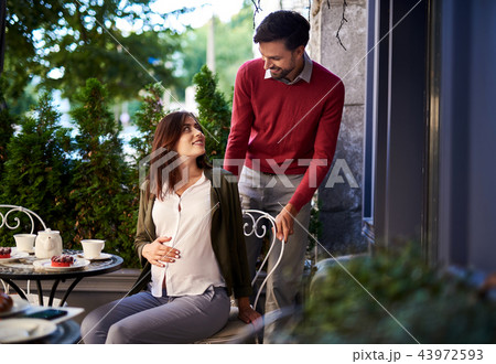Caring bearded man pulling chair out for his beautiful wife 43972593