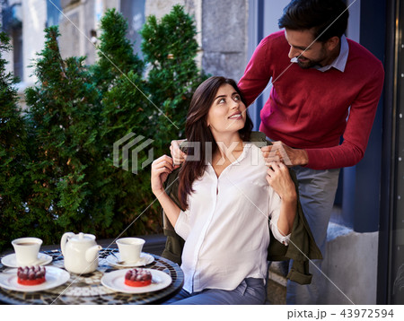 Caring bearded man putting jacket on his charming wife 43972594