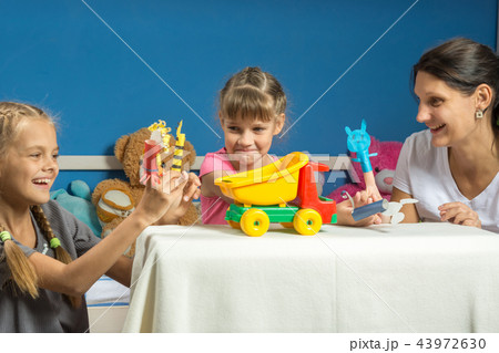 Mom plays with two daughters in a self-made finger puppet theater Mom plays with two daughters in a self-made finger puppet theater 43972630