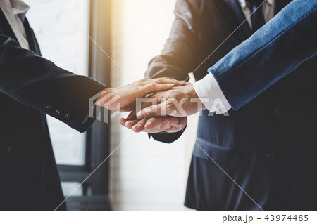 Image of business people joining and putting hands together duri 43974485