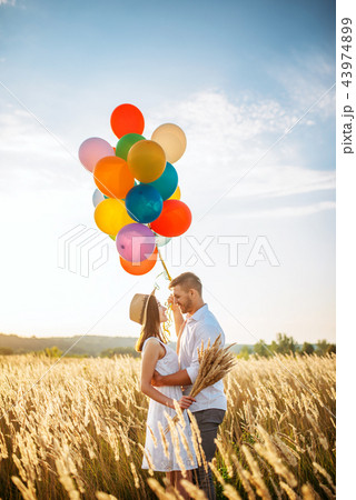 Love couple with balloons hugs in wheat field 43974899