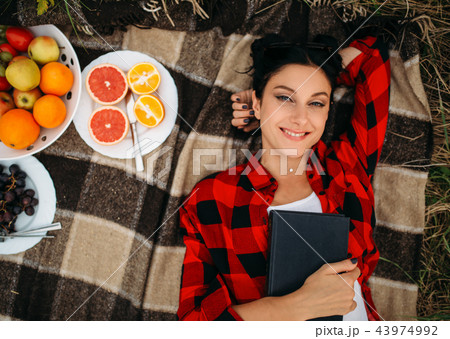 Woman lies on plaid, top view, picnic in field 43974992