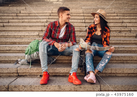 Tourists with backpacks resting on the stone steps Tourists with backpacks resting on the stone steps 43975160