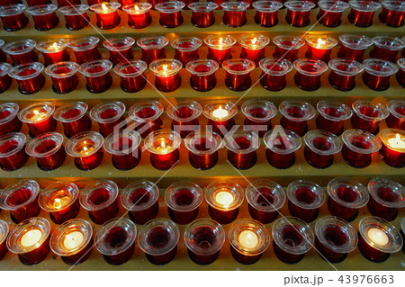 Many lighted candles in candlesticks. Sacred light Many lighted candles in candlesticks. Sacred light 43976663