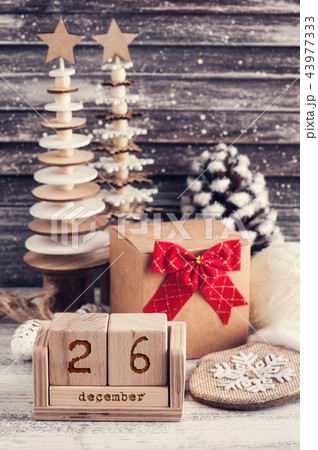 Craft gift box, red bow, wooden christmas trees Craft gift box, red bow, wooden christmas trees 43977333