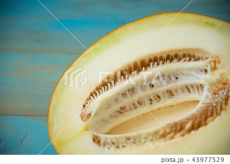 half ripe melon on a rustic, blue wooden background 43977529