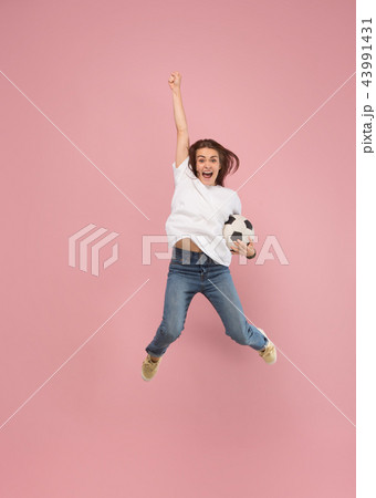Forward to the victory.The young woman as soccer football player jumping and kicking the ball at 43991431