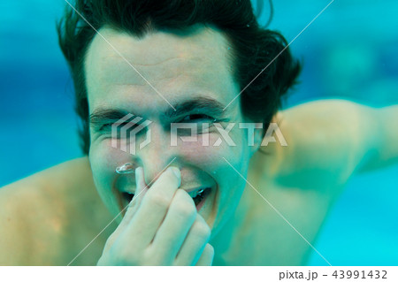 A man closing nose under the pool 43991432