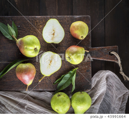 fresh ripe green pears lie on a brown wooden board 43991664