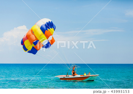 Couple of tourists flying on a colorful parachute 43993153