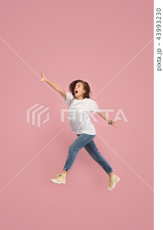 Freedom in moving. Pretty young woman jumping against pink background 43993230