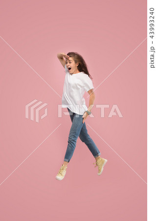 Freedom in moving. Pretty young woman jumping against pink background 43993240
