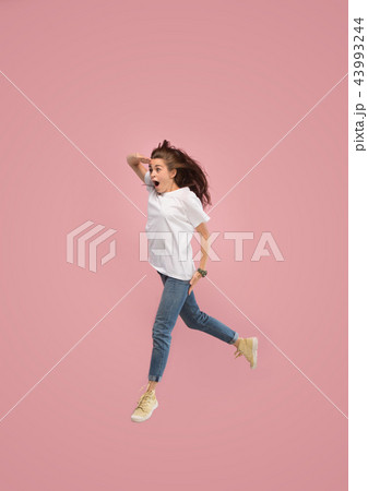 Freedom in moving. Pretty young woman jumping against pink background 43993244