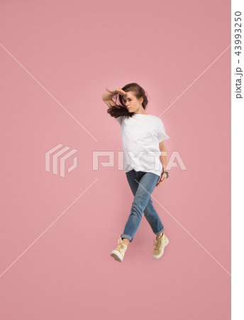 Freedom in moving. Pretty young woman jumping against pink background 43993250