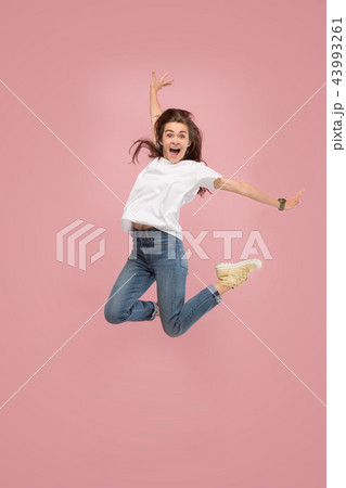 Freedom in moving. Pretty young woman jumping against pink background Freedom in moving. Pretty young woman jumping against pink background 43993261