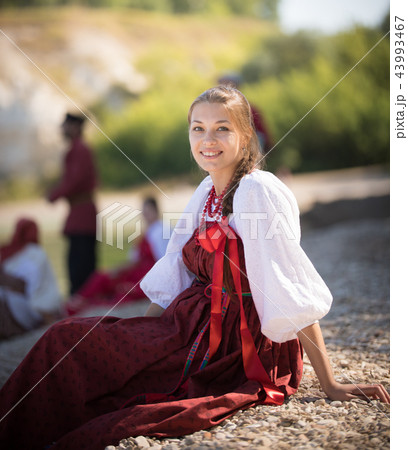 A beautiful girl in Russian national costume pose for the camera on the background of an amazing A beautiful girl in Russian national costume pose for the camera on the background of an amazing 43993467