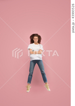 Freedom in moving. Pretty young woman jumping against pink background 43993526