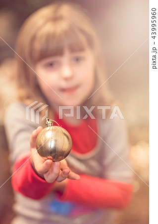 Cute girl holding Christmas decoration 43995960