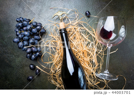 A bottle of red wine with grapes 44003701