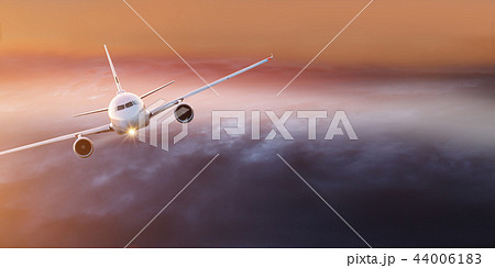 Commercial airplane flying above dramatic clouds. 44006183