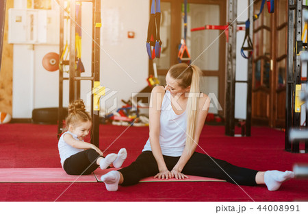 Mom and daughter together perform different exercises 44008991