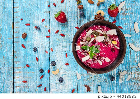 Smoothie bowl with fresh berries, nuts, seeds, fruit and vegetables. Smoothie bowl with fresh berries, nuts, seeds, fruit and vegetables. 44013935