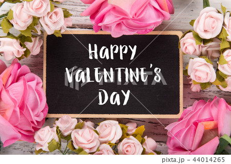 Small chalkboard for Valentine's day. Background with pink roses. 44014265